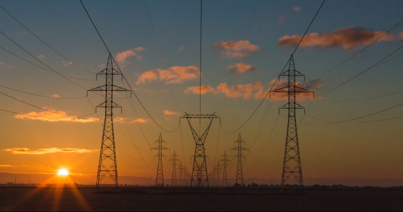 Electricity pylons at sunset, Leading Resolutions was asked to support Drax with an acquisition and subsequent transition/integration of Scottish Power