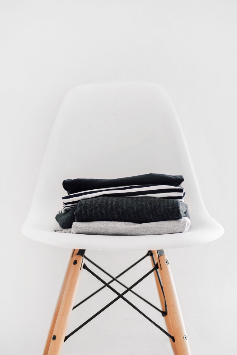White chair with dark folded jumpers on top, to support the major investment programme to create a world class IT Service, Selfridges embarked on a programme of IT investments to provide the business with the tools to do their job